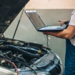 A person using a computer a monitor an engine