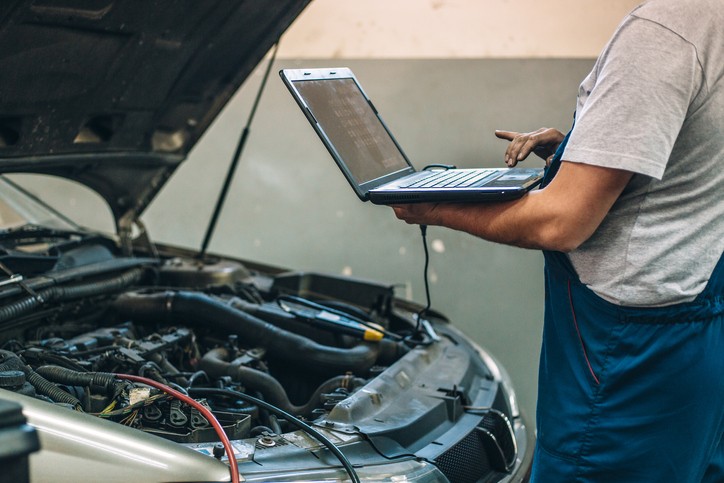 A person using a computer a monitor an engine