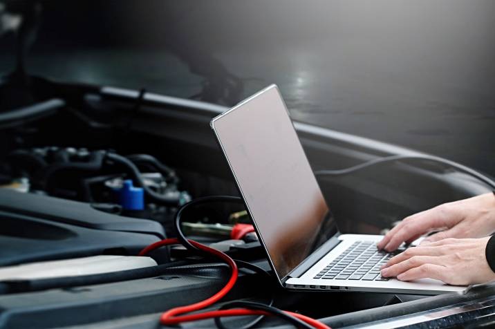 Mechanic performing a diagnostic test on a car engine