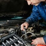 Close-up of a car diagnostic tool being plugged into a car's OBD-II port