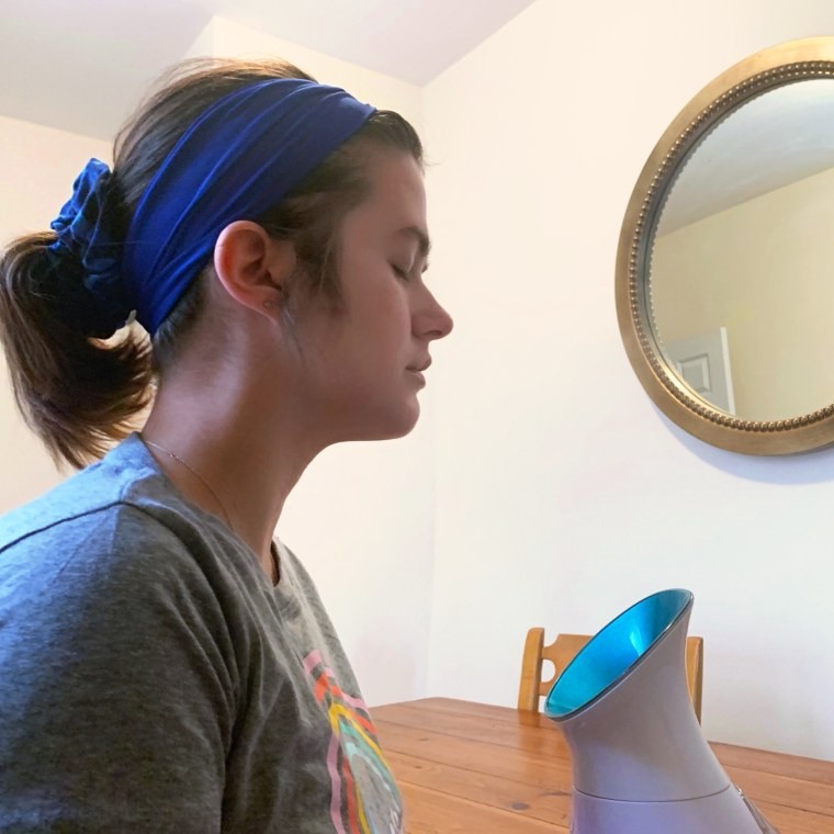 Woman using Pure Daily Care Facial Steamer for home facial treatment