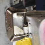 Bent hook attachment of a slide hammer, illustrating tool failure during car door pin removal.