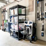 Garage shelving unit filled with organized storage bins and lawn care supplies