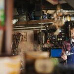 Mechanic inspecting car engine with tool